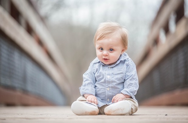 baby Ryan Cochran sitting on a bridge