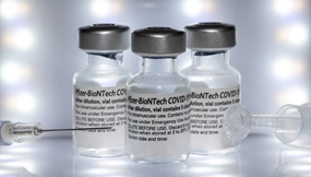 3 Pfizer-BioNTech COVID vaccine bottles with needle syringe