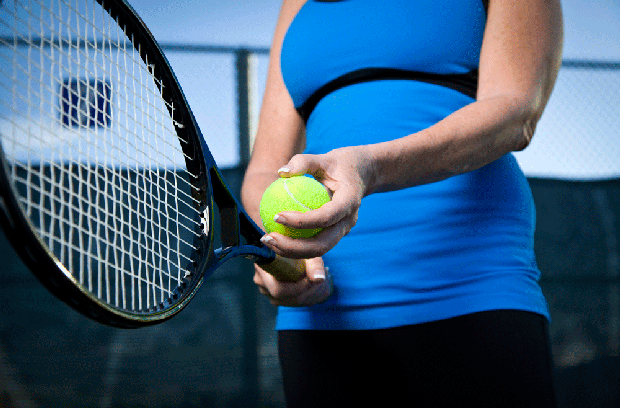 Woman holding tennis racket and tennis ball