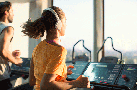 Woman with headphones on treadmill