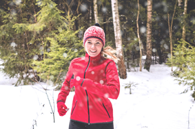 young woman running outside in snowy woods