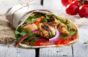 Grilled chicken wrap with onions, lettuce and tomatoes