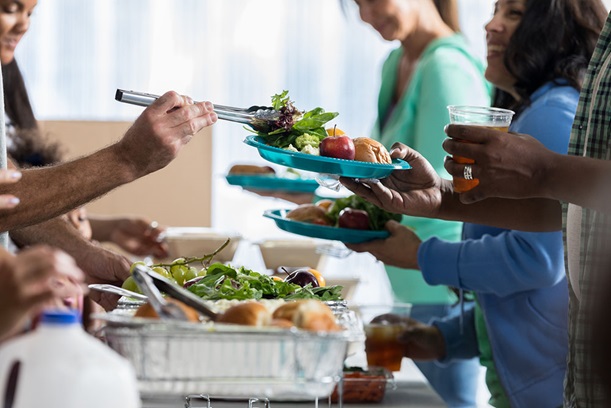 close-up of volunteers serving guests food