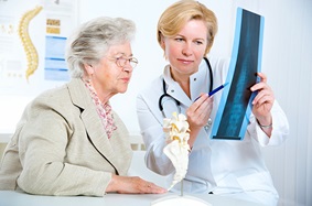 a provider holding up an xray for a patient