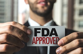 Man holding a sign that says "FDA approved"