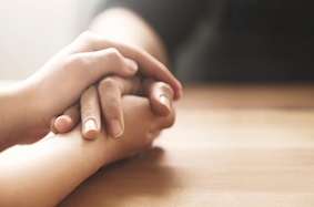 two people holding hands across a table