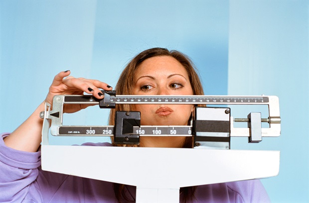 woman weighing herself on a scale