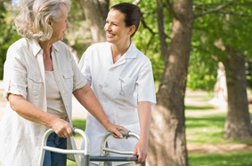 woman using a walker while another woman helps
