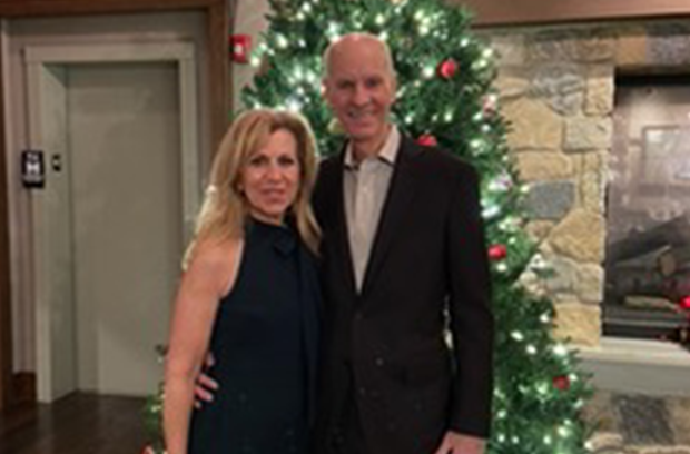 tom murray and his wife in front of a christmas tree