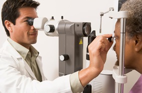 male doctor holding eye device to female patient