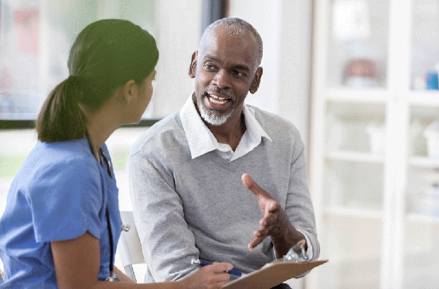 Provider holding a clipboard while talking to patient