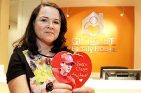 Melissa holding heart with picture of her donor on it