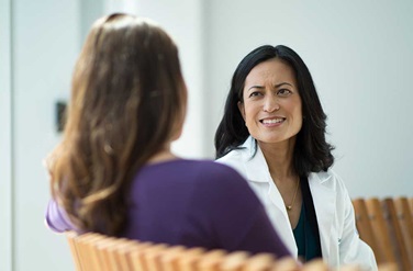 Smiling doctor talking with patient