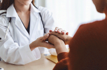 Female doctor holding patient's hand