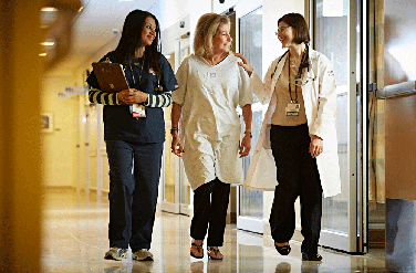 Providers walking with patient in hallway